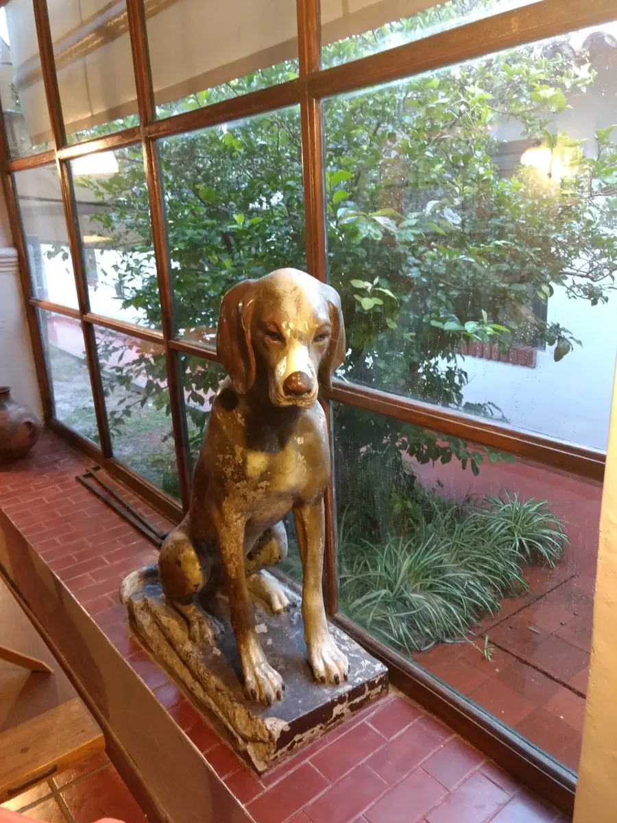 La estatua de un perro, de más de cien años, junto a la ventana del living.