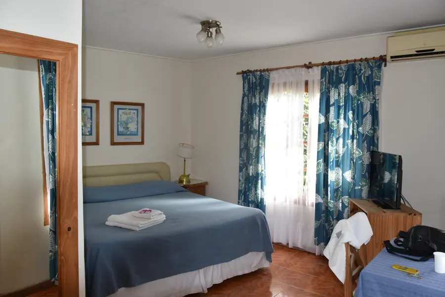 Habitación doble con cortinas estampadas en azul.