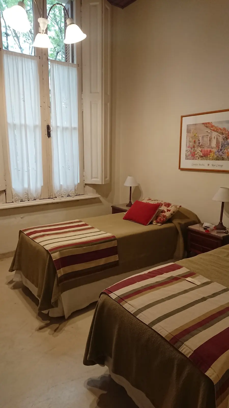 Habitación twin con dos camas y acolchados a rayas.