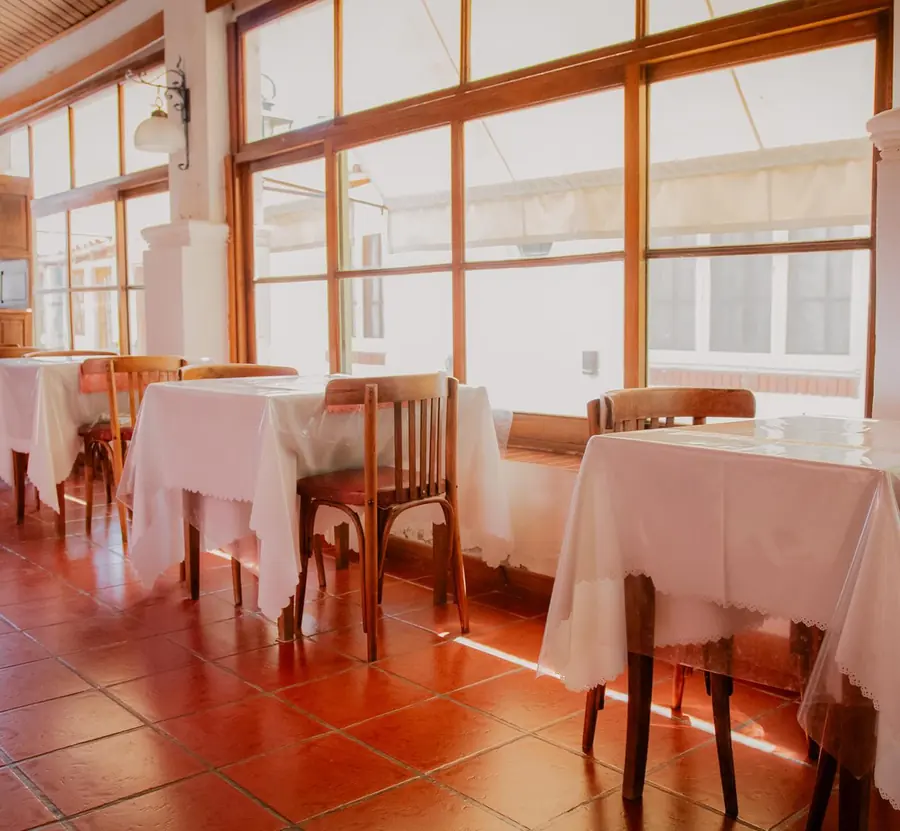 El salón con las mesas junto a los ventanales.